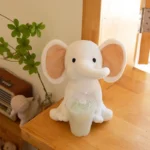 peluche elephant blanc oreilles roses sur la table