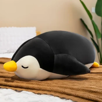 peluche pingouin kawaii noir allongé sur le ventre