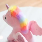 peluche licorne ailé rose vue sur sa crinière couleur arc en ciel avec ses ailes roses